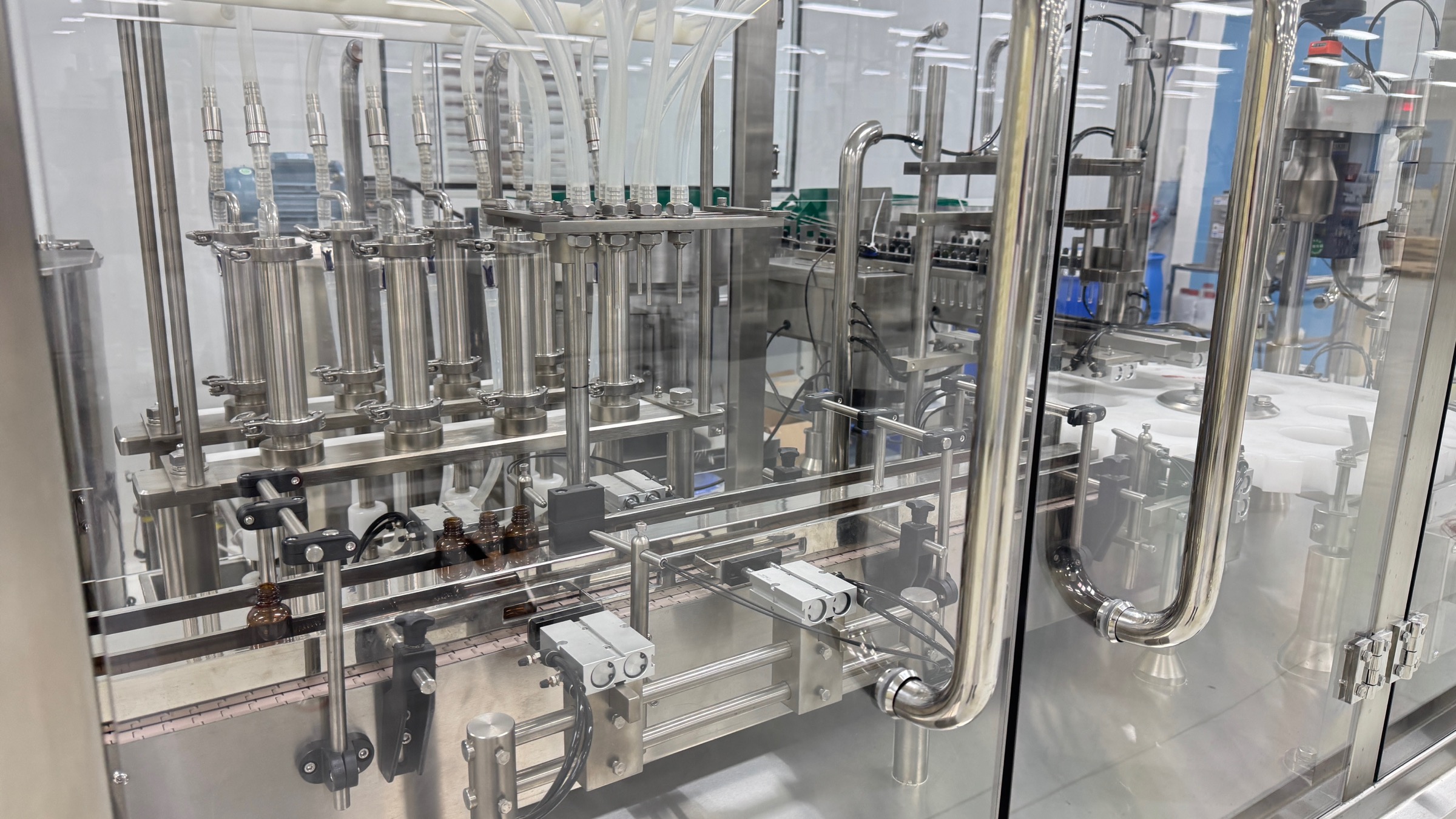 Automated tincture filling line dispensing liquid into dropper bottles